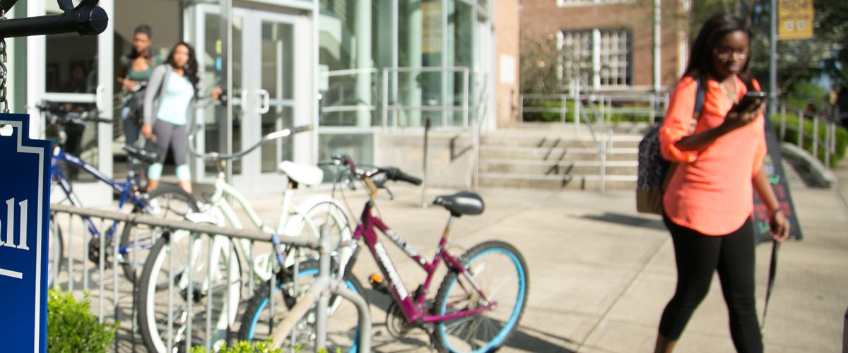 students walking and bicycles in a rack