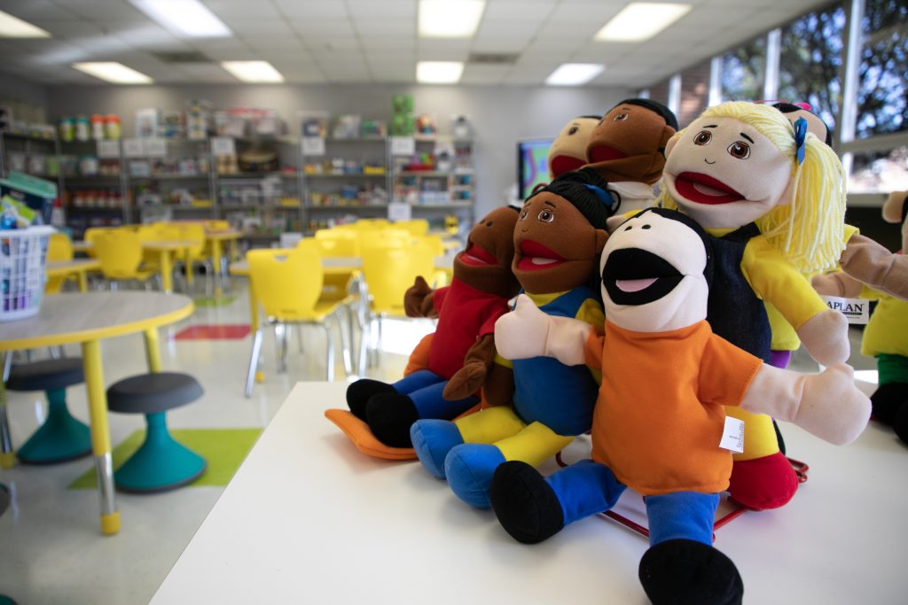 hand puppets sit on a shelf in a new classroom