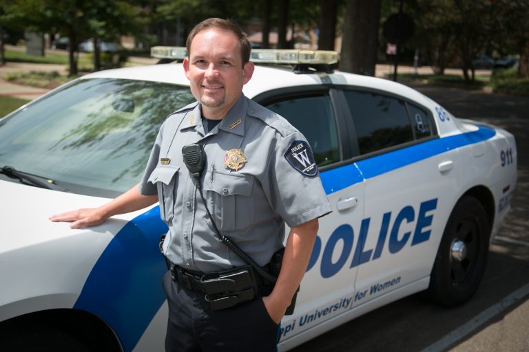 Police chief standing beside police car