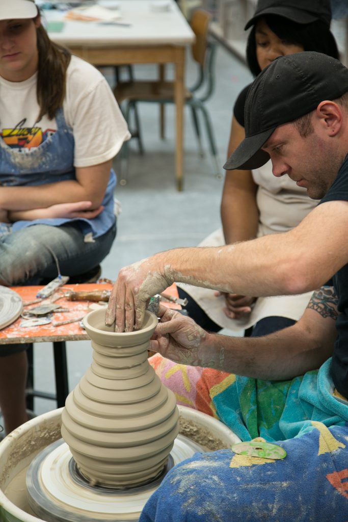 Ceramics professor demonstrates a pottery technique