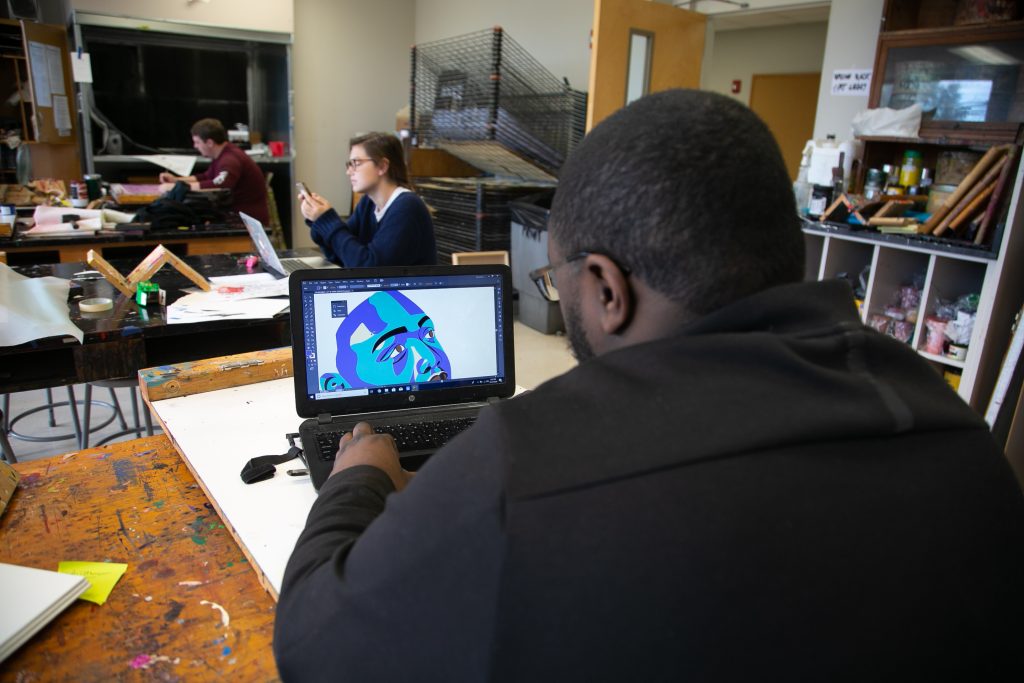 Male student illustrates on a computer