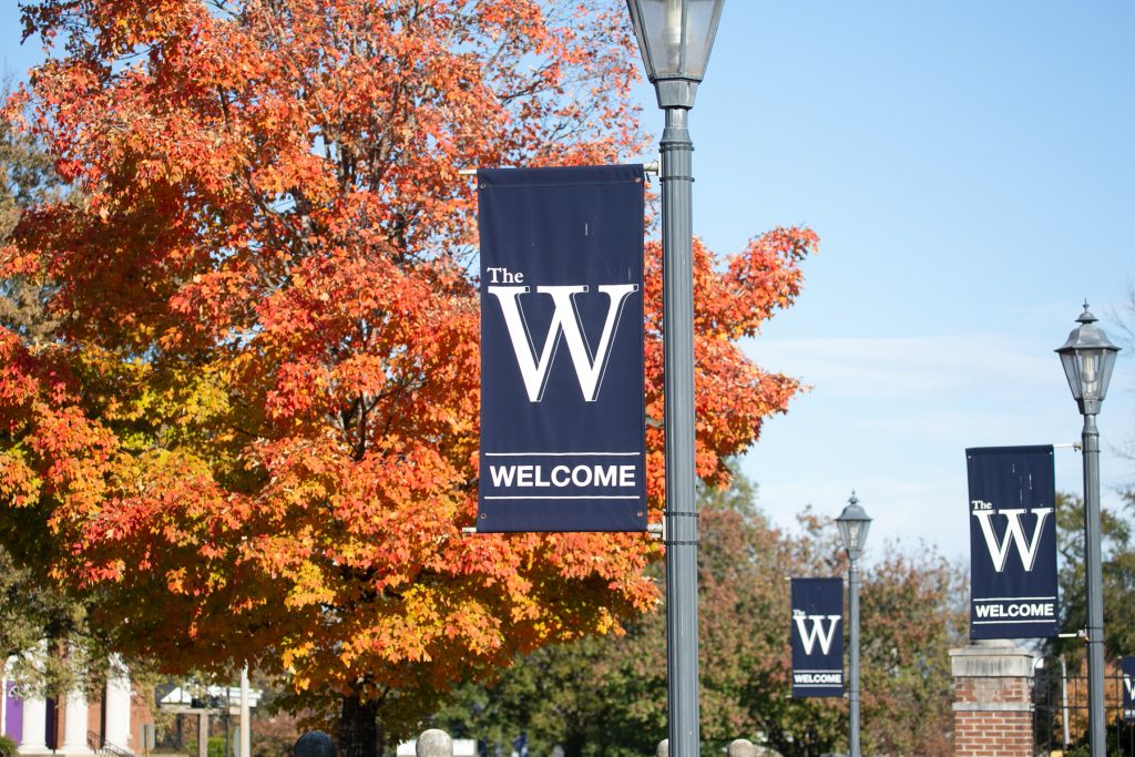W Banners in front of autumn trees on campus