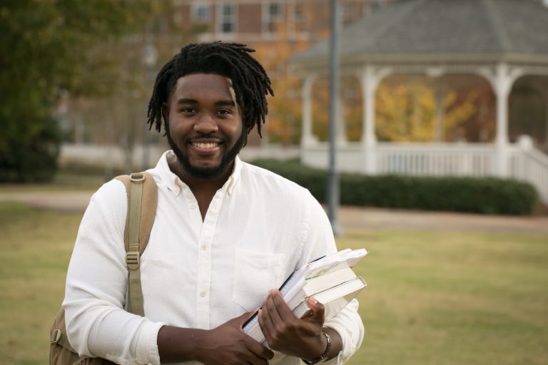 Man holding textbooks outdoors
