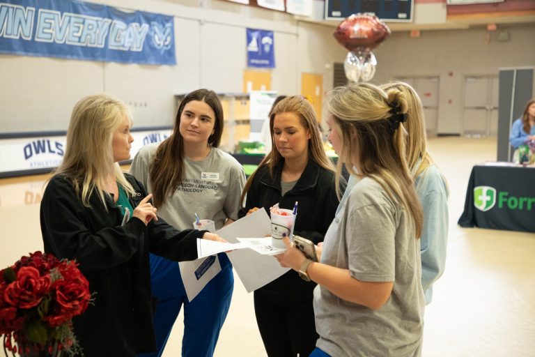 Photo of W students talking with an employer representative during the Healthcare Career Fair. 