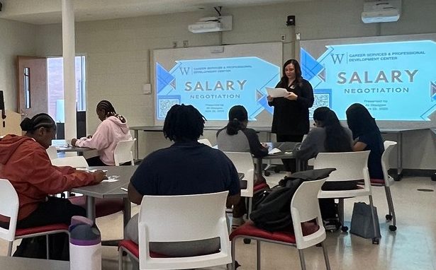 Photo of a bank representative leading students in a budget activity