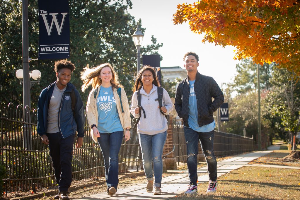 two men and two women walking outdoors in fall