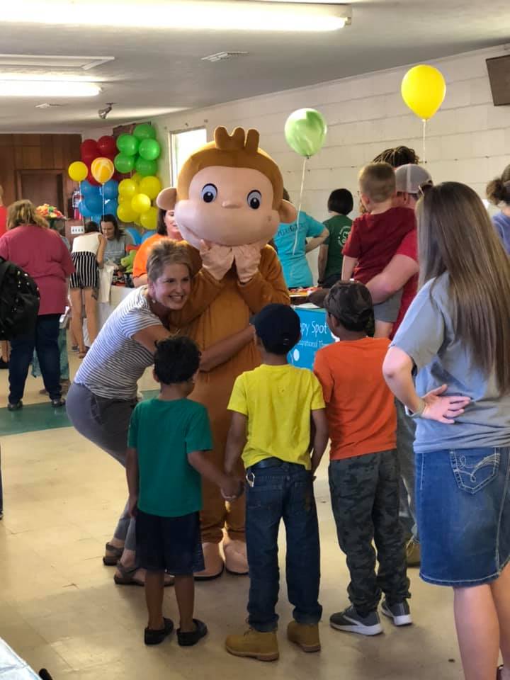 A group of children meet Curious George