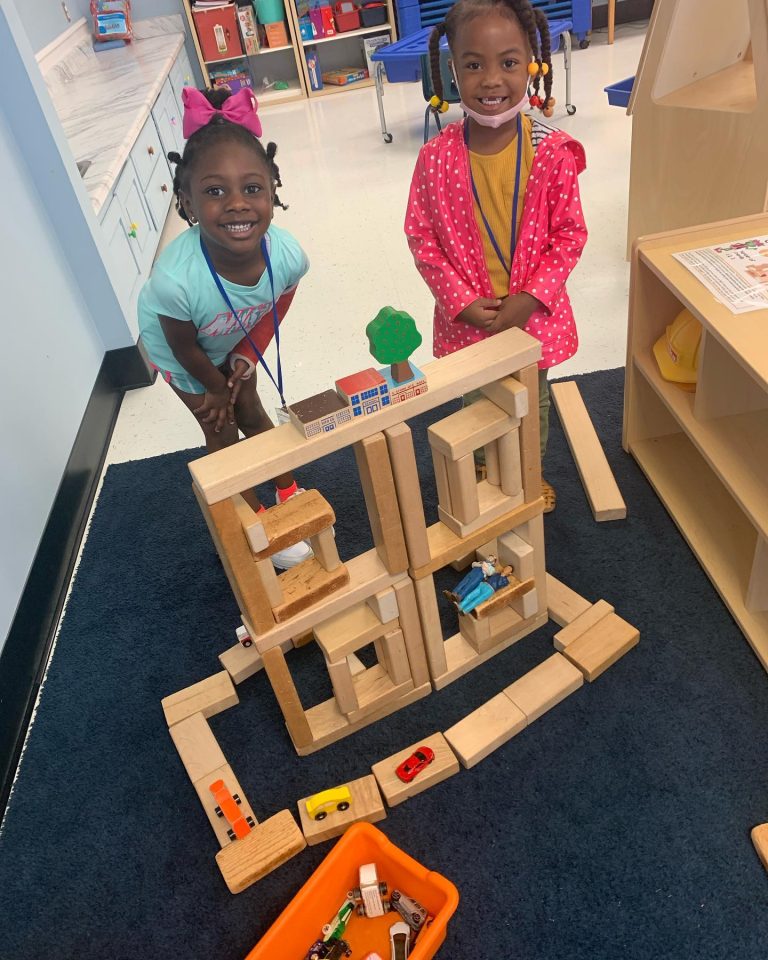 Two CPDC students play with a tower of blocks