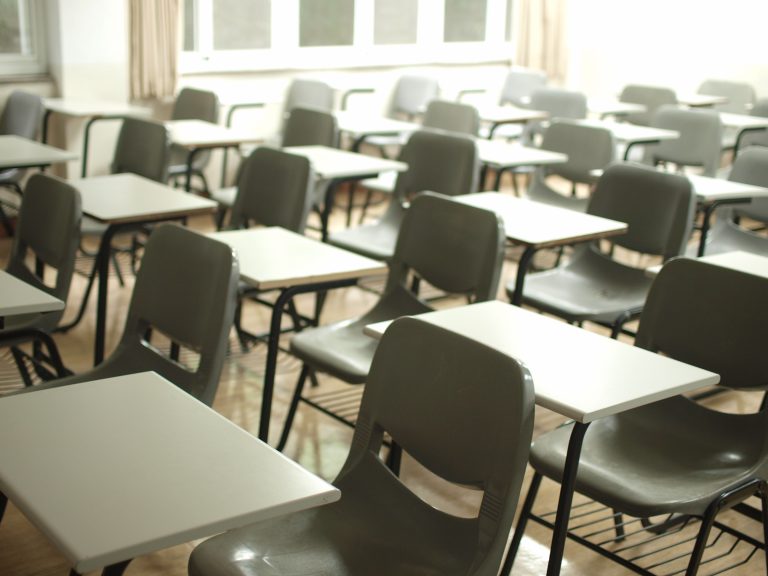 Rows of empty student desks in a classroom