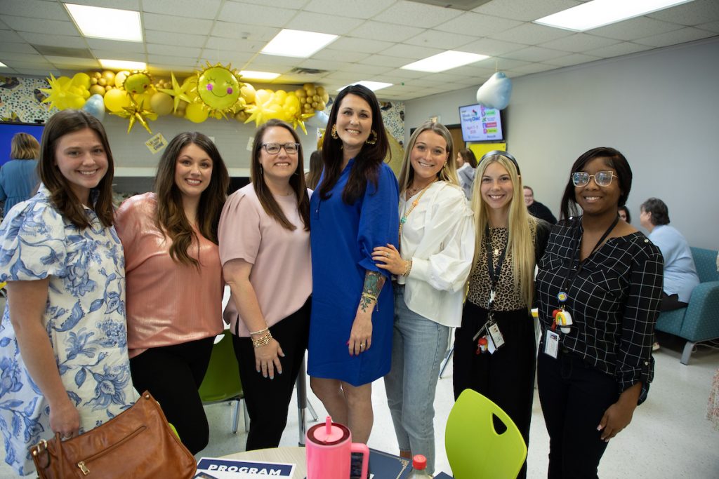 Upcoming education graduates getting a picture with their Internship University Supervisor. 