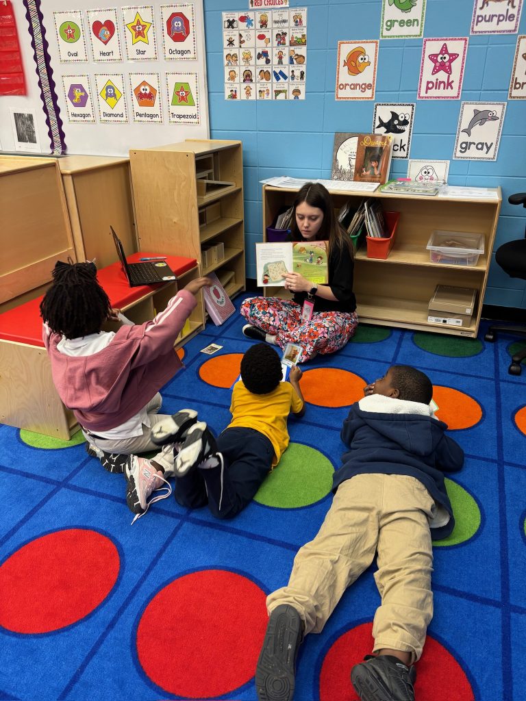 Elementary students being read aloud to in a small group
