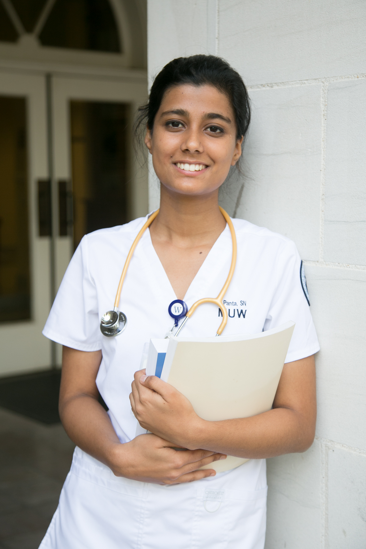 woman in nurse uniform holding books