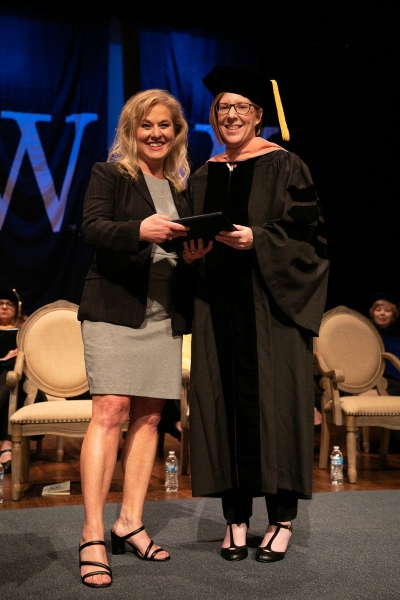 Two women hold award