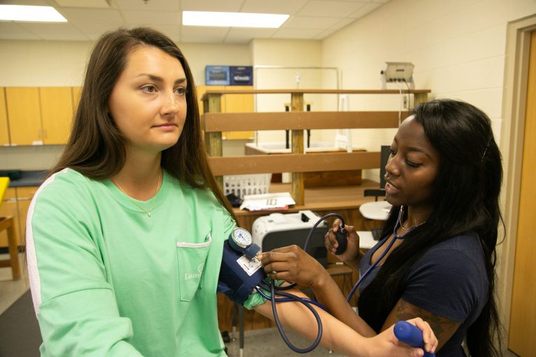 A student checks the blood pressure of another student