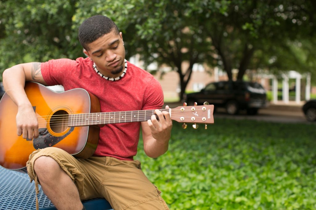 man playing guitar outside