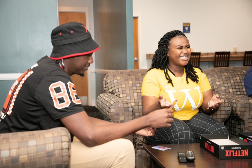 Man and woman laugh in lobby of residence hall