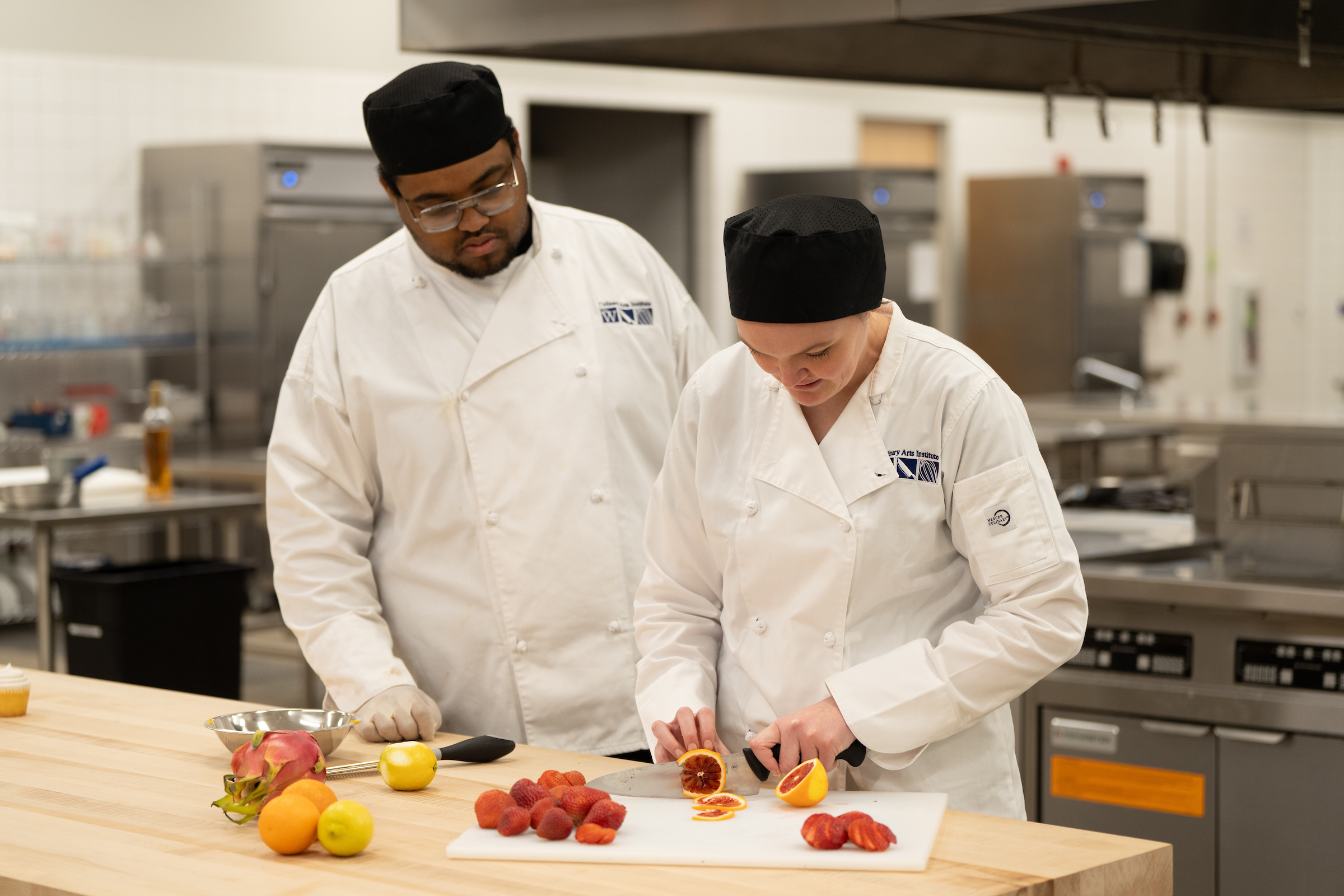 Two student chefs preparing food.