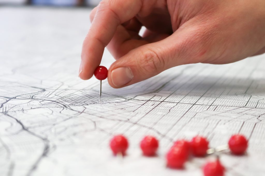Close up of a hand placing a pin in a map