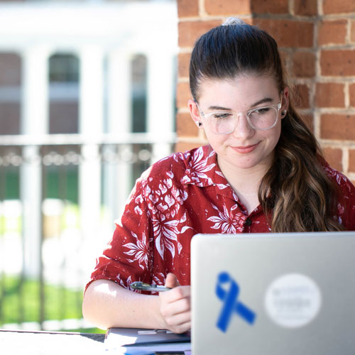 Woman studies with a laptop outdoors
