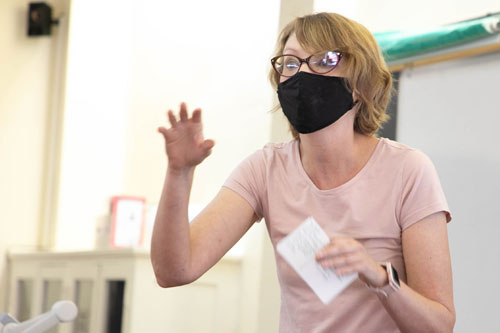 Dr. Erin Kempker lectures to class wearing a facemask