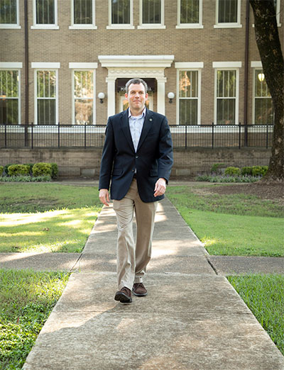 Dr. Scott Tollison walks in front of Poindexter Hall