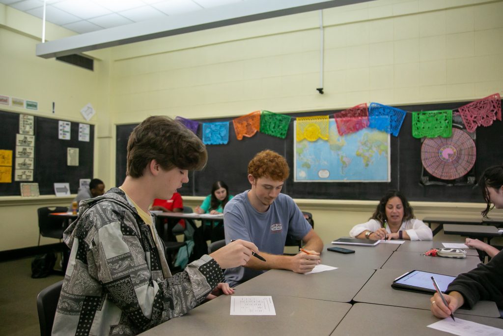 Students sit around a table in a foreign language class