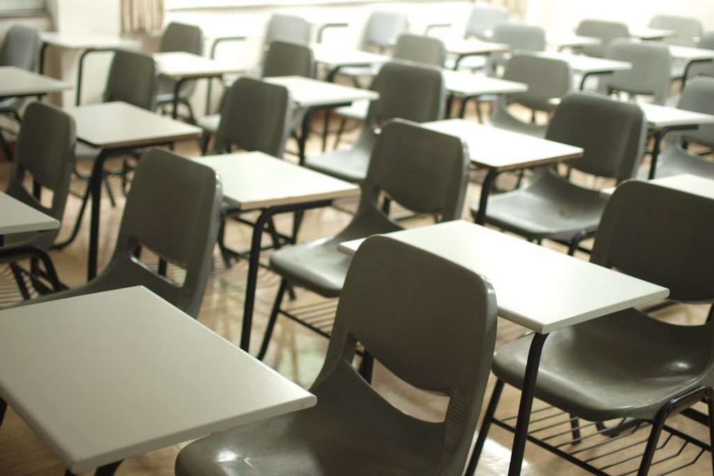 Rows of empty student desks in a classroom