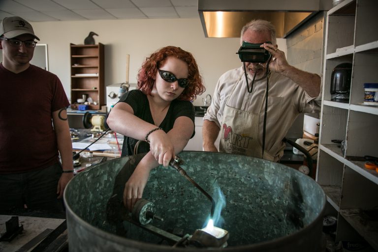 woman with blowtorch in art studio