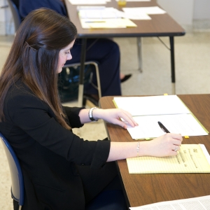 Woman wrting on legal pad during Mock Trial event