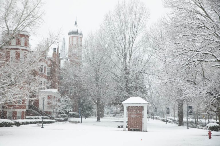 Snow covers the clocktower and front campus