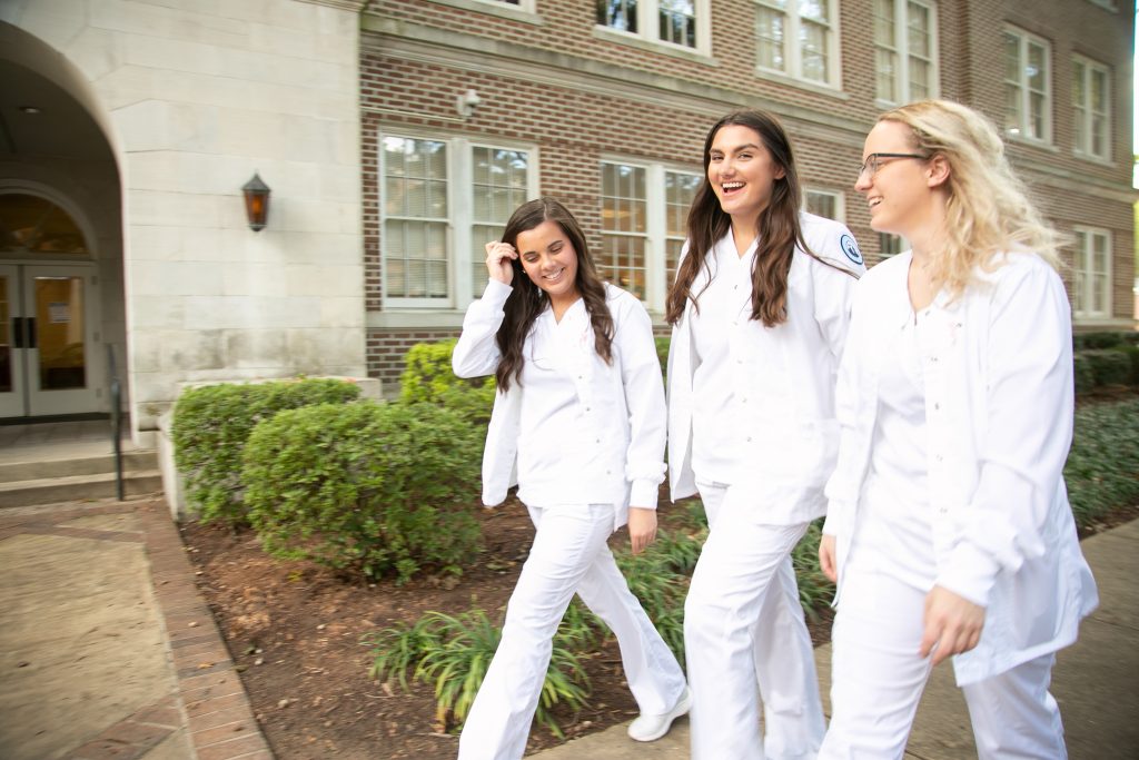 Three nursing students in uniform walking outside