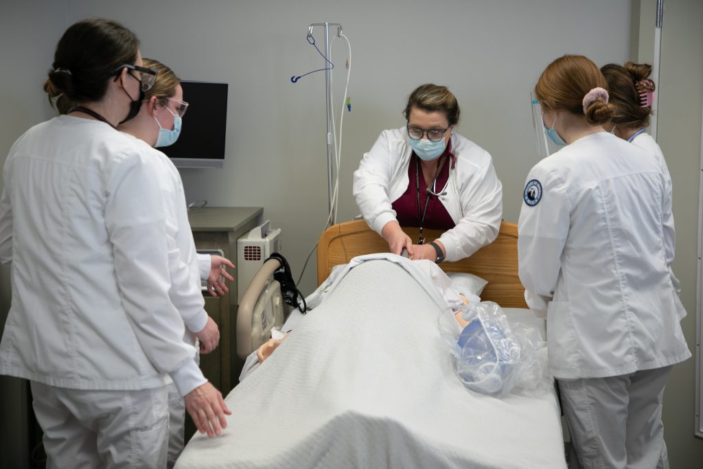 Nursing students work on a simulated patient