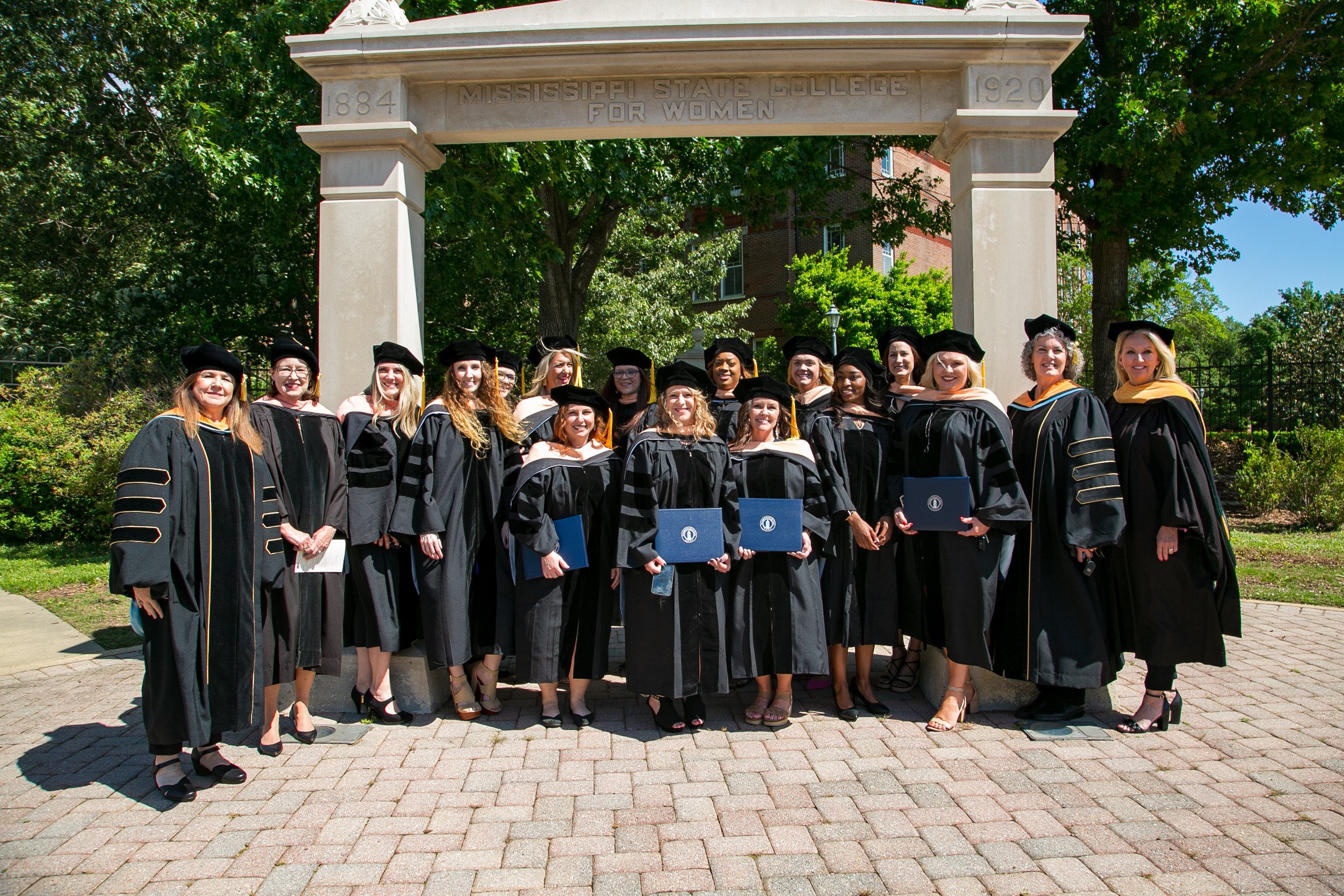Doctoral class in regalia in front of Old Maid's Gate