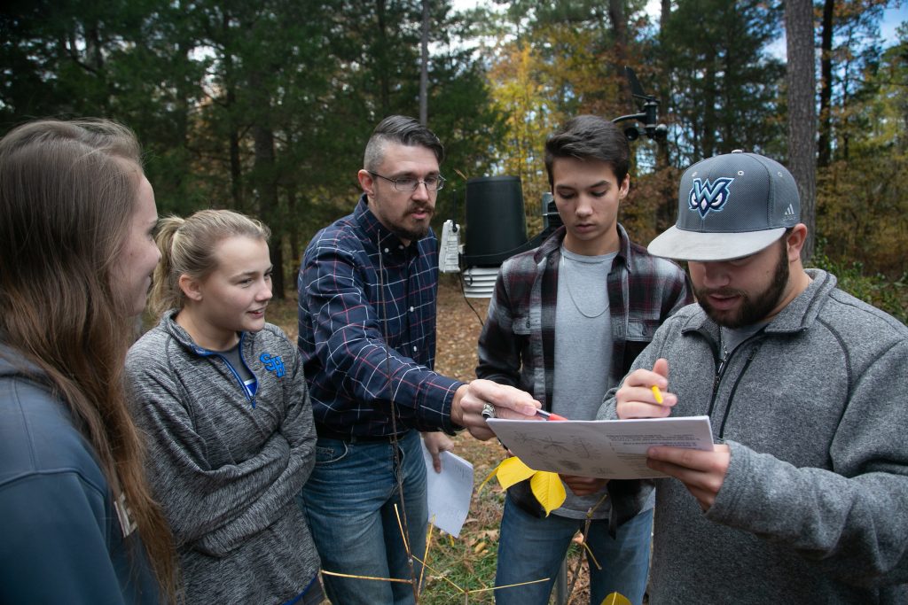 Biology Instructor Thomas Dodson instructs students during field research