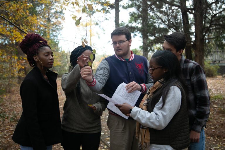 Students examine a leaf during field research