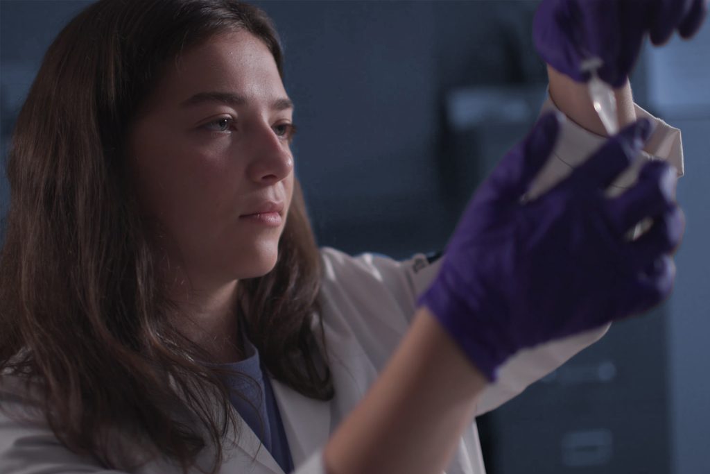 A student holds a sample in a biology lab
