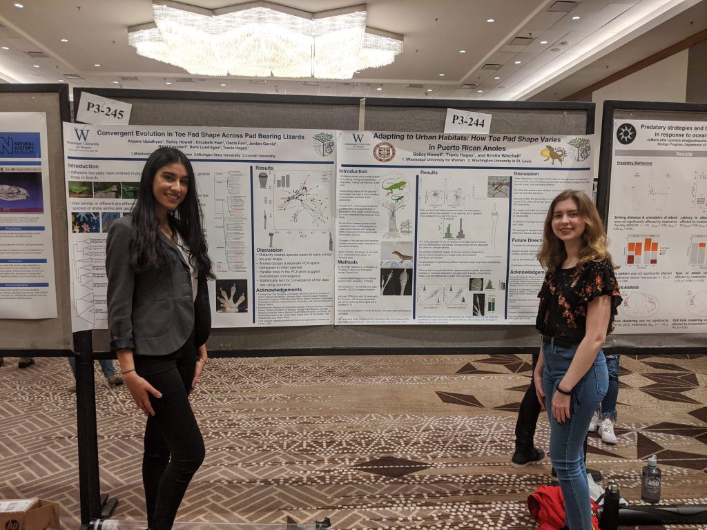 Two students standing next to research posters.