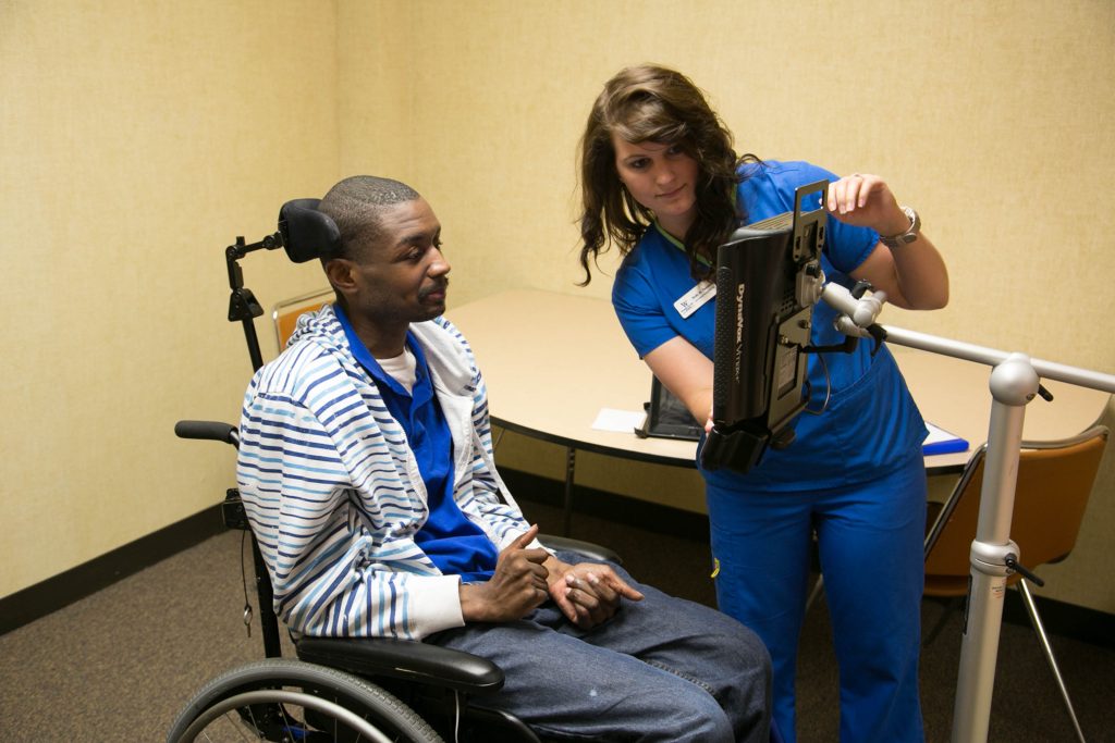 A student works with a man in a wheelchair