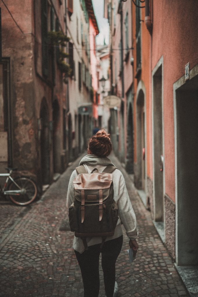 Woman with backpack walks down a european street