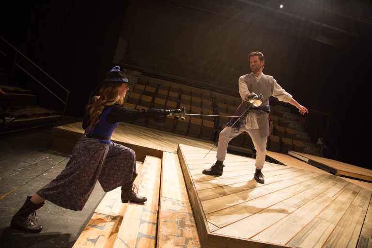 Students cross swords on the stage