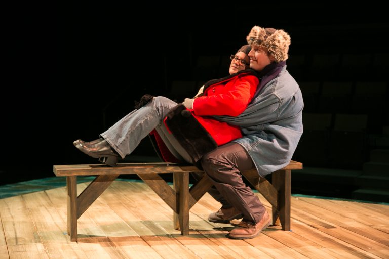 Two actors on a bench on stage