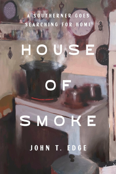 Picture of old-fashioned white stove with a steaming black dutch oven on one eye, which is bright red, along with two other pans and a clock and spice rack on the wall behind and to the side. The title House of Smoke: A Southerner Goes Searching for Home, John T. Edge are superimposed on the photo.