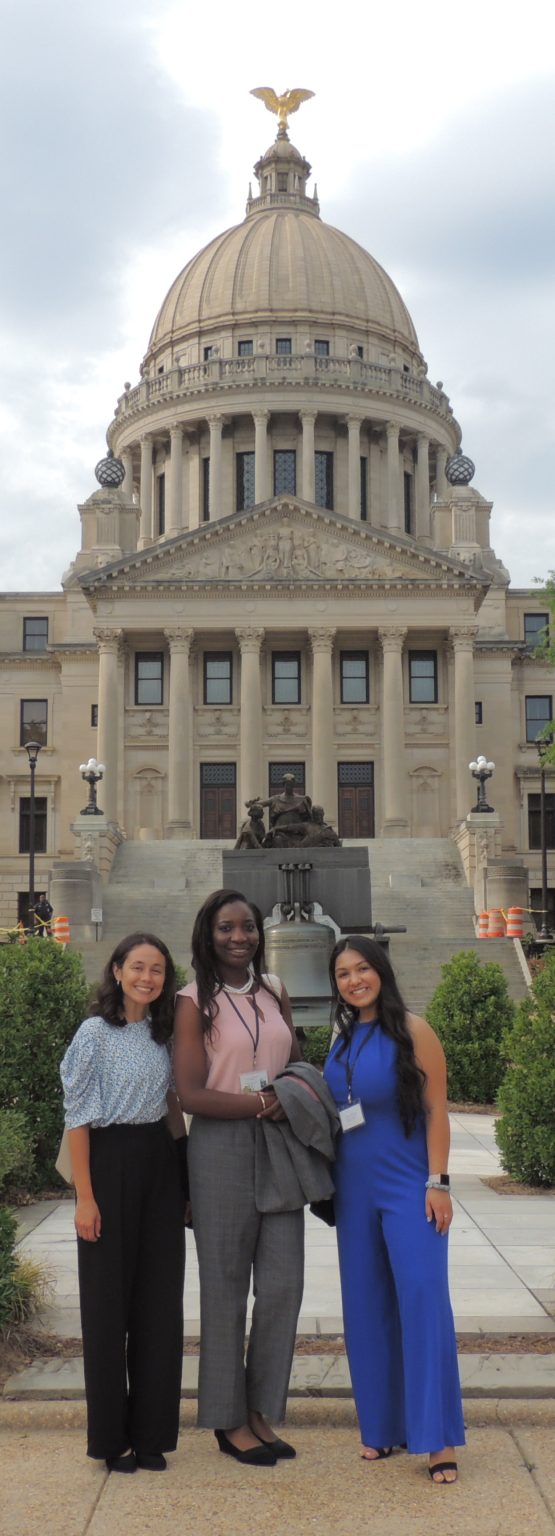 3 NEW Leadership Mississippi participants stand in front of the Mississippi Capitol