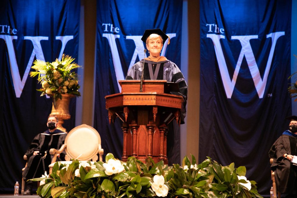 President Miller stands at a lectern in regalia