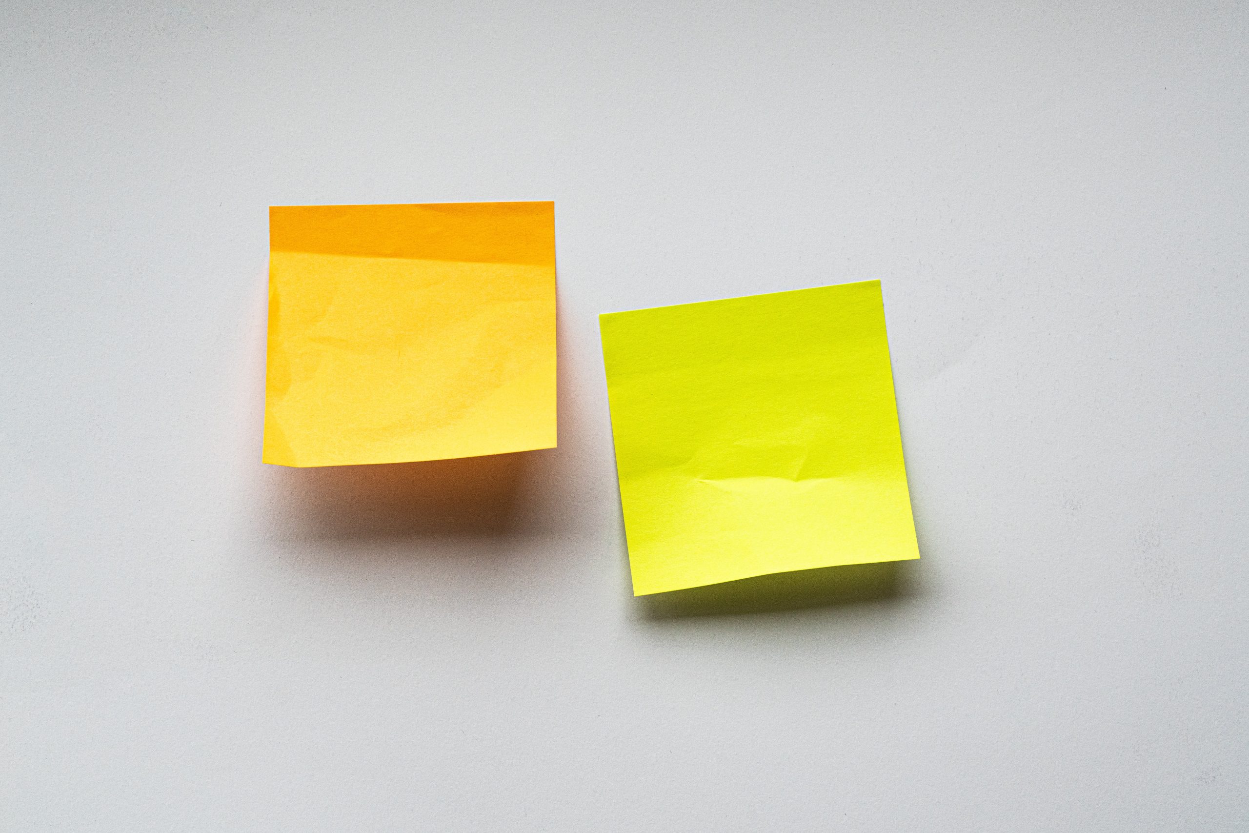 Two sticky notes on a white wall