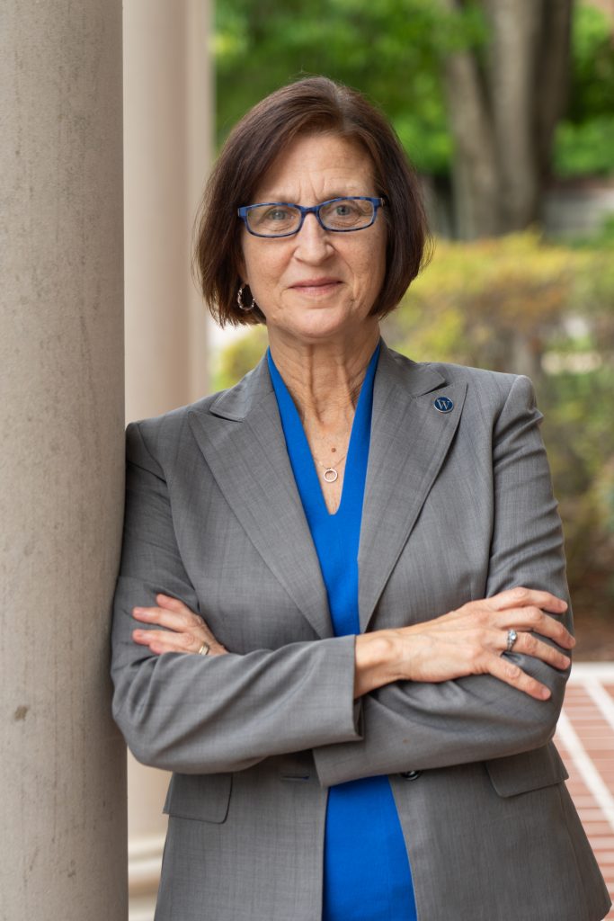 Kim Whitehead poses in front of campus building 