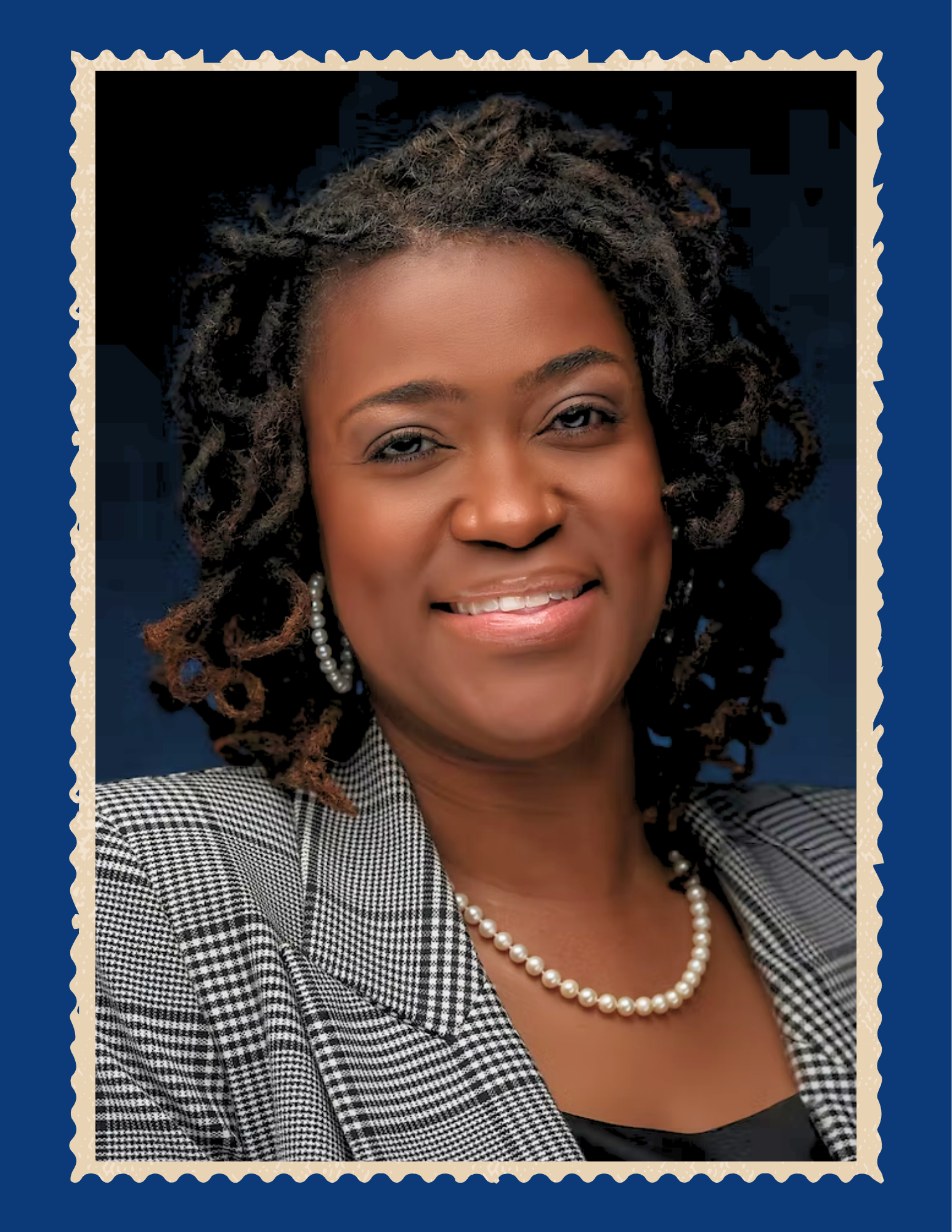 Headshot of Dr. Daphne Chamberlin. She smiles with her head slightly tilted and wears a black and white plaid blazer and dons a pearl necklace and pearl hoop earings. Her should-length hair is styled in curly locs.