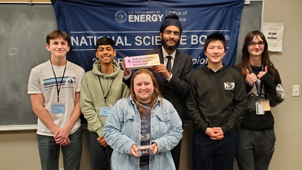 Students hold a sign and trophy indicating that their team, MSMS won the Regional Science Bowl