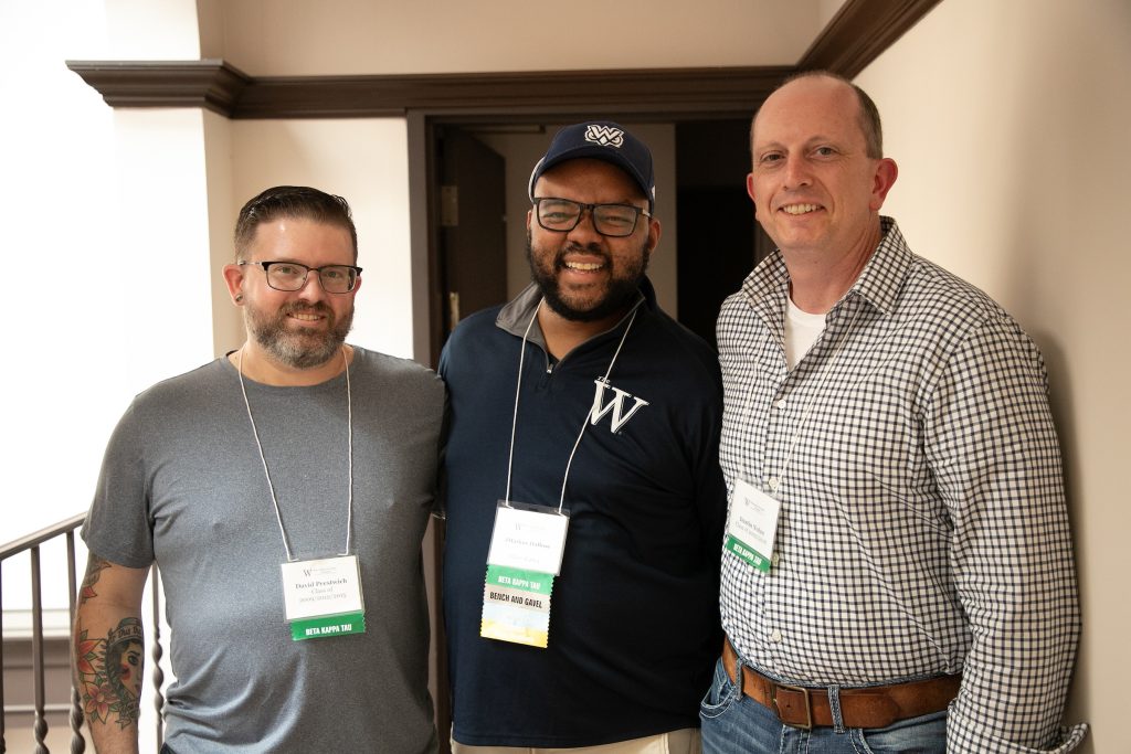 three male alumni pose for picture