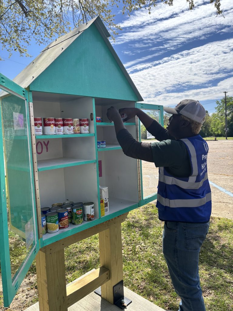 A student stocks a blessing box.